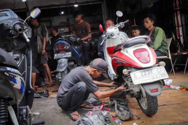 Montir memeriksa kondisi sepeda motor milik konsumen di bengkel Berkah Motor, Duren Tiga, Pancoran, Jakarta Selatan, Kamis (4/4/2024). Foto: Jamal Ramadhan/kumparan