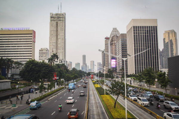 Sejumlah kendaraan melintas dengan latar belakang gedung bertingkat di Jalan Jenderal Sudirman, Jakarta, Senin (19/8/2024). Foto: Darryl Ramadhan/kumparan