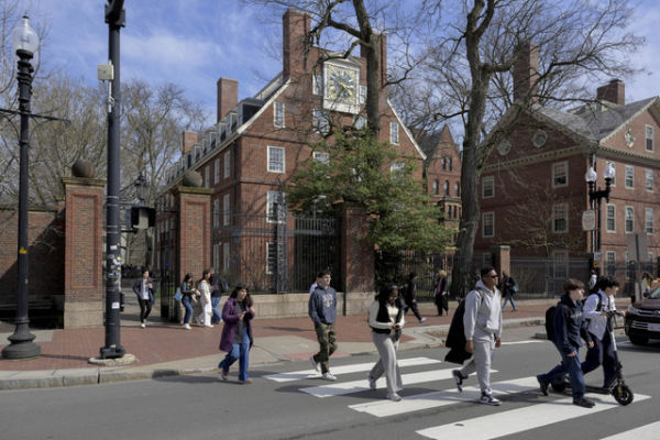Para mahasiswa berjalan di luar Harvard Yard di Universitas Harvard di Cambridge, Massachusetts, AS, Selasa (15/4/2025). Foto: Faith Ninivaggi/REUTERS