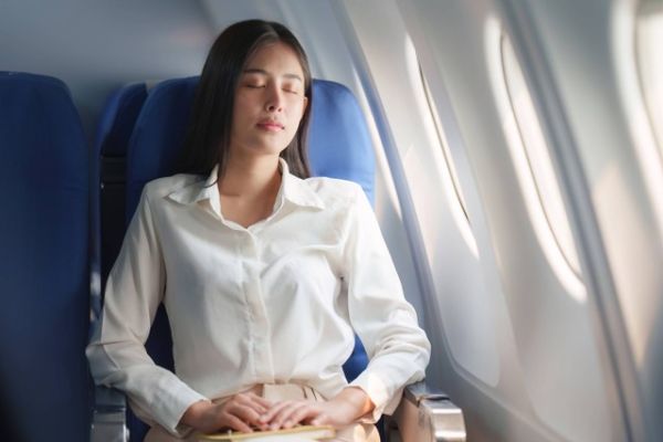 Ilustrasi penumpang tidur di pesawat. Foto: Worawee Meepian/Shutterstock