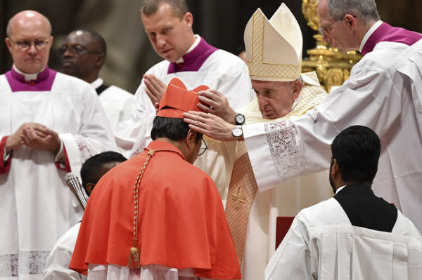 Paus Fransiskus (kanan) mengenakan topi berretta (Biretta) saat melantik Kardinal Indonesia Ignatius Suharyo Hardjoatmodjo (kiri) dalam Konsistori Publik Biasa untuk pelantikan kardinal baru di Basilika Santo Petrus di Vatikan. Foto: Tiziana Fabi/AFP
