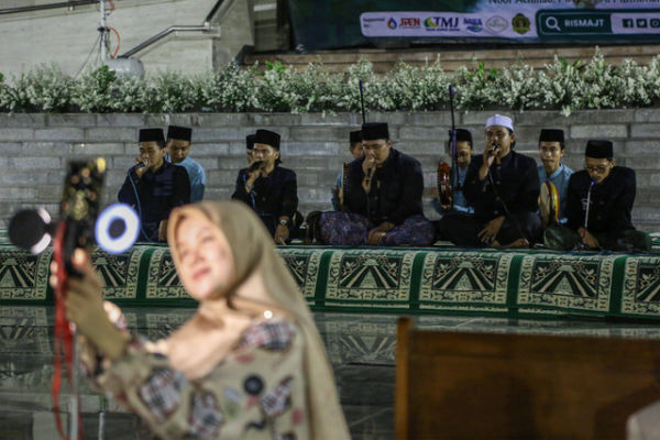 Sejumlah warga menyaksikan peserta melantunkan selawat diiringi tabuhan alat musik rebana dalam Parade 12 Jam Shalawat di Masjid Agung Jawa Tengah (MAJT), Semarang, Jawa Tengah, Rabu (27/9/2023). Foto: Makna Zaezar/Antara Foto