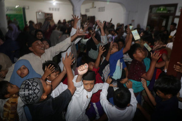 Jamaah berebut koin dan uang kertas yang dilempar oleh sesama jamaah di Masjid Jami Jamsaren, Kota Kediri, Jawa Timur, Rabu (27/9/2023). Foto: Prasetia Fauzani/Antara Foto