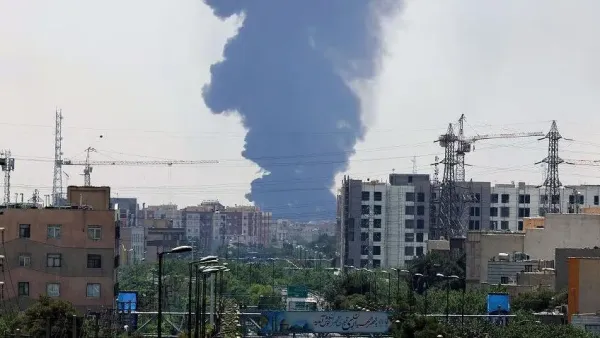 Asap membumbung setelah Israel melancarkan serangan di bagian selatan Teheran, pada Minggu (15/06).