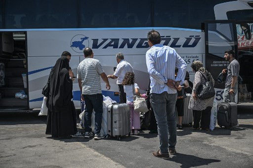 Ketiadaan penerbangan di Iran membuat sejumlah warga naik bus saat hendak berpergian keluar masuk Iran Foto: Ozan Kose/AFP