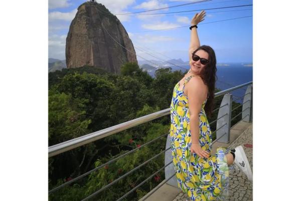 A woman in a yellow dress overlooking a mountain