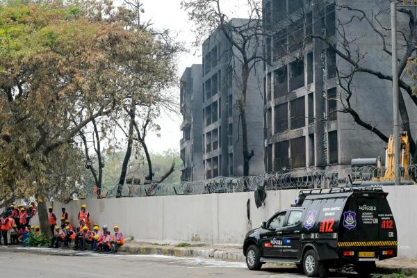 Workers wait to clear debris from the crash site of Air India flight 171, outside charred buildings at a residential area near the airport in Ahmedabad on June 16, 2025. Indian health officials have begun handing relatives the bodies of their loved ones who were among at least 279 killed in one of the worlds worst plane crashes in decades, but most families were still waiting on June 16 for results of DNA testing. (Photo by Dibyangshu SARKAR / AFP)