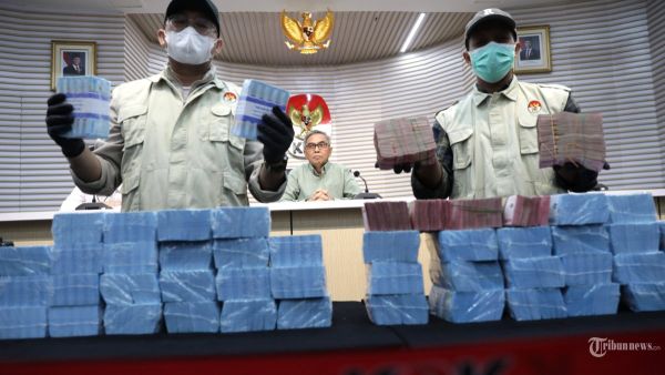 Barang Bukti - Petugas menunjukkan barang bukti disaksikan Ketua KPK Setyo Budiyanto terkait operasi tangkap tangan (OTT) di Kabupaten Ogan Komering Ulu (OKU), Sumatera Selatan saat konferensi pers di Gedung KPK, Jakarta, Minggu (16/3/2025). KPK resmi menahan enam tersangka diantaranya Ketua Komisi III DPRD OKU M Fahrudin, Anggota DPRD OKU Ferlan Juliansyah, Ketua Komisi II DPRD OKU Umi Hartati, Kepala Dinas PUPR OKU Nopriansyah dan pihak swasta M Fauzi dan Ahmad Sugeng Santoso dan mengamankan barang bukti berupa uang tekait kasus dugaan suap pengadaan barang dan jasa di Dinas PUPR Kabupaten Ogan Komering Ulu Tahun 2024-2025. TRIBUNNEWS/IRWAN RISMAWAN