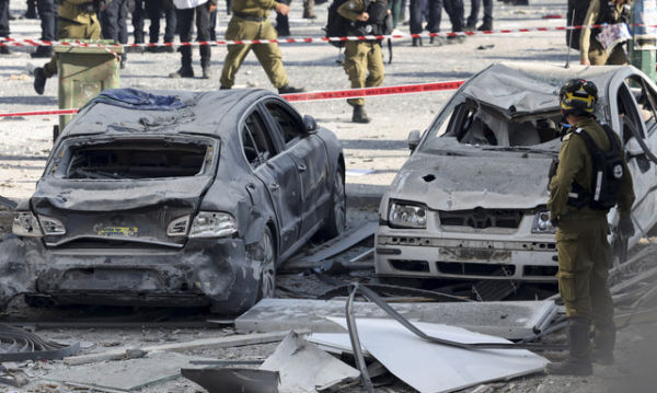 Seorang petugas penyelamat berdiri di samping mobil-mobil yang rusak di lokasi benturan setelah serangan dari Iran ke Israel, di Ramat Gan, Israel, Kamis (19/6/2025). Foto: Nir Elias/REUTERS