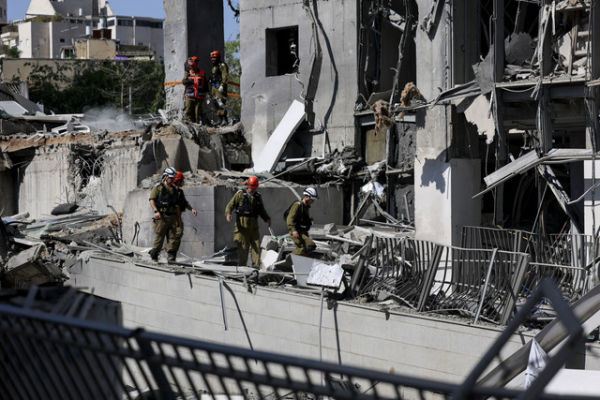 Petugas darurat bekerja di lokasi kejadian setelah serangan rudal dari Iran ke Israel, di Ramat Gan, Israel, Kamis (19/6/2025). Foto: Ammar Awad/REUTERS