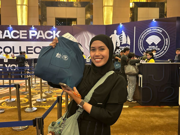 Salah satu peserta Mandiri Jogja Marathon 2025 mengambil race pack. Foto: kumparan