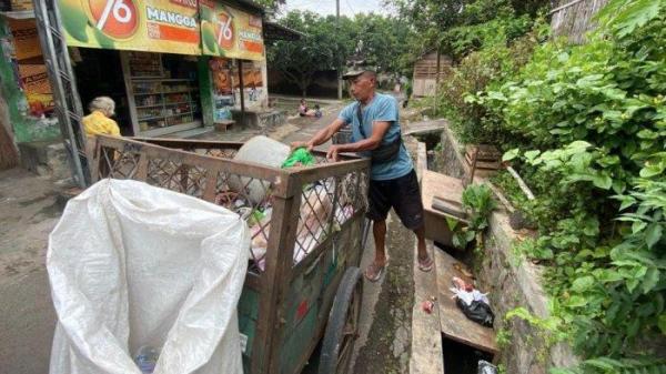 PTT JADI PEMULUNG - Agus Subiantoro saat bertugas mengangkut sampah di Desa Kembang, Kecamatan Bondowoso pada Jum'at (20/6/2025)