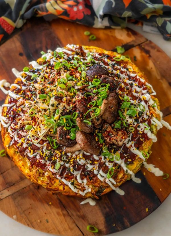 This may contain: a pizza covered in toppings sitting on top of a wooden cutting board