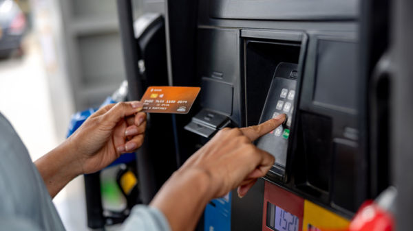 Person typing in credit card PIN at gas pump