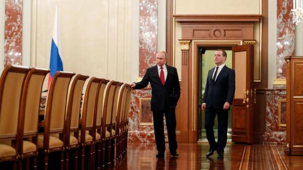 Russian President Vladimir Putin and Medvedev speak before a meeting with members of the government in Moscow. (AFP Photo)