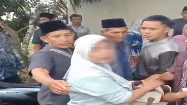 Tangkap layar video yang diunggah akun Facebook Tia Agstna, Jumat (1/2/2024). Dalam video ini terlihat warga menangkap seorang ibu-ibu yang disebut mencuri uang di rumah duka orang meninggal.