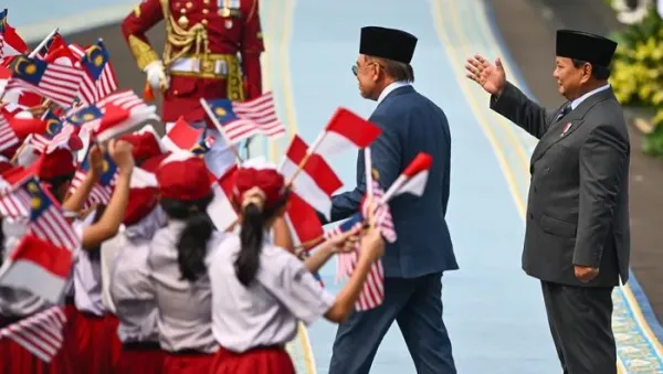 Presiden Prabowo Subianto (kanan) bersama Perdana Menteri Malaysia Anwar Ibrahim (kedua kanan) menyapa para siswa SD dalam upacara kenegaraan di Istana Merdeka, Jakarta, Jumat (27/6/2025). Kunjungan kenegaraan PM Malaysia Anwar Ibrahim di Istana Kepresidenan Jakarta tersebut untuk membahas hubungan bilateral, tindak lanjut dari sejumlah agenda ASEAN di Kuala Lumpur beberapa waktu lalu, serta bertukar pandangan soal dinamika kawasan dan global yang menjadi perhatian bersama. ANTARA FOTO/Hafidz Mubarak A/app/nym.