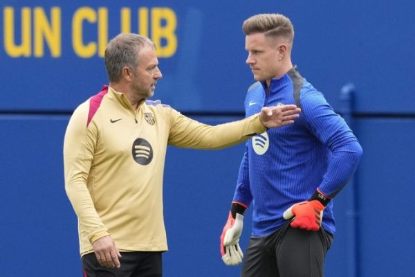 HLV Flick trao đổi với Ter Stegen trên sân tập Barca. Ảnh: EFE