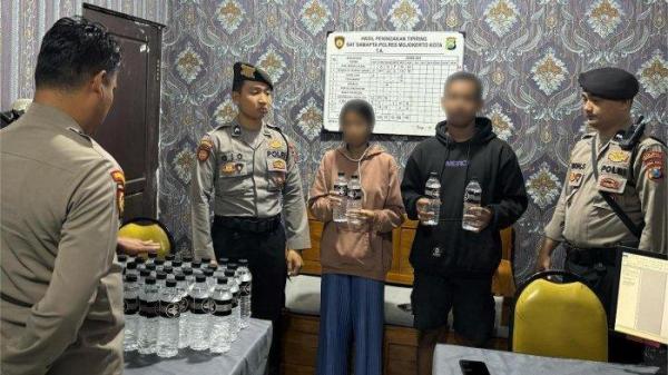 MIRAS ILEGAL - Pelaku pengedar miras Ilegal asal Sidoarjo, beserta barang bukti 56 botol miras diamankan di Polres Mojokerto Kota.