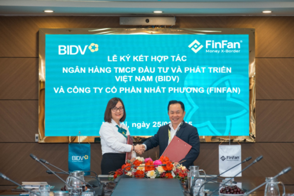 Trinh Thi Thu Trang (L), Deputy Director of BIDV Thang Long Branch, and Nguyen Tuyen, CEO of FinFan, shake hands at the signing ceremony. Photo courtesy of FinFan