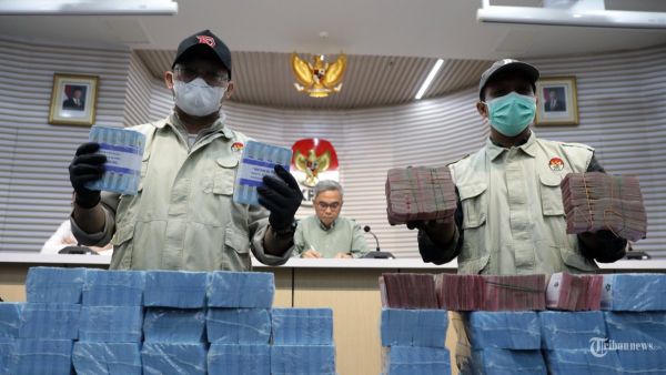 Barang Bukti - Petugas menunjukkan barang bukti disaksikan Ketua KPK Setyo Budiyanto terkait operasi tangkap tangan (OTT) di Kabupaten Ogan Komering Ulu (OKU), Sumatera Selatan saat konferensi pers di Gedung KPK, Jakarta, Minggu (16/3/2025). KPK resmi menahan enam tersangka diantaranya Ketua Komisi III DPRD OKU M Fahrudin, Anggota DPRD OKU Ferlan Juliansyah, Ketua Komisi II DPRD OKU Umi Hartati, Kepala Dinas PUPR OKU Nopriansyah dan pihak swasta M Fauzi dan Ahmad Sugeng Santoso dan mengamankan barang bukti berupa uang tekait kasus dugaan suap pengadaan barang dan jasa di Dinas PUPR Kabupaten Ogan Komering Ulu Tahun 2024-2025. TRIBUNNEWS/IRWAN RISMAWAN