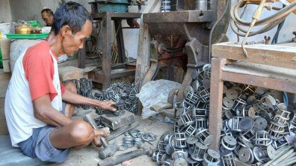 PROSES PRODUKSI - Seorang pekerja sedang membuat kerangka kompor semawar di industri rumahan milik Husni Mubarok di Desa Gembong, Kecamatan Talang, Kabupaten Tegal, Senin (30/6/2025).