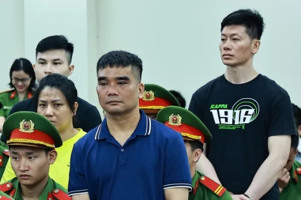 Former police officer Nguyen Van Hung (front row) and Huong Mau (yellow shirt) at court. Photo by Read/Danh Lam