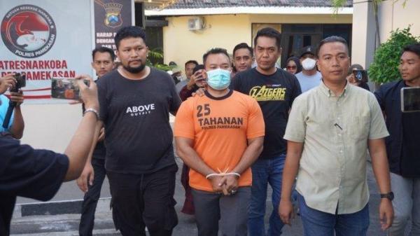 GURU ANIAYA KURIR - Zainal Arifin tersangka penganiayaan kurir lantaran paket Hp yang dipesan istrinya tak sesuai gambar, saat digiring masuk ke ruang tahanan Polres Pamekasan, Madura, pada Rabu (2/7/2025).