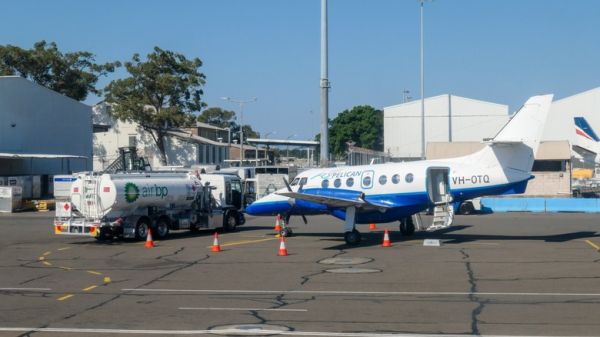 A fuel truck pulling up beside a small plane