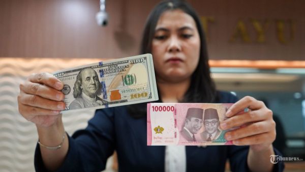 NILAI TUKAR RUPIAH - Petugas menunjukan uang pecahan dolar AS di gerai penukaran mata uang asing Ayu Masagung, Jakarta Pusat, Senin, (8/4/2025). Nilai tukar rupiah terhadap dolar AS pada hari ini dibuka pada posisi Rp 16.850 per Dolar AS atau melemah 1,78 persen. Usai libur Lebaran Idulfitri 1446 H. Ambrolnya rupiah ini disebabkan oleh sejumlah sentimen yang datang dari global, utamanya kebijakan tarif Donald Trump. Tribunnews/Jeprima