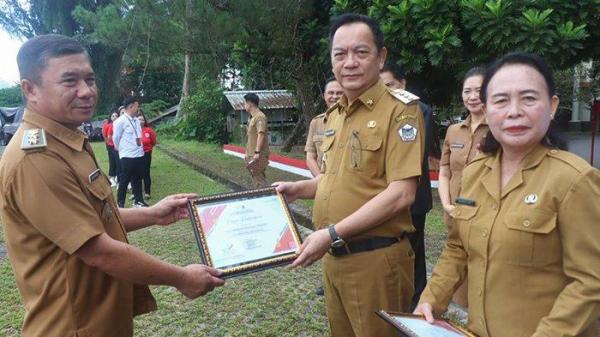 Penyerahan piagam penghargaan kepada Lurah Pangolombian