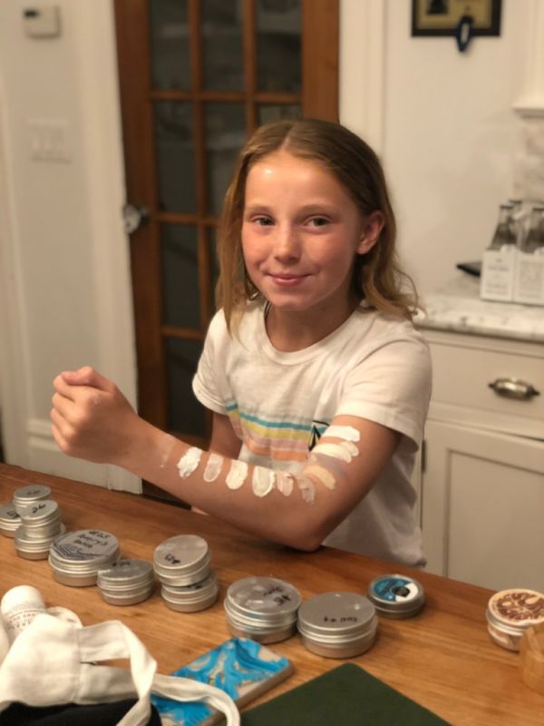 Girl testing different sunscreen samples on her arm.
