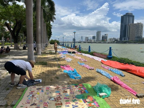 Giữa trưa nắng, người dân đến trải bạt ở bờ sông Hàn ‘xí chỗ’ xem chung kết pháo hoa - Ảnh 1.