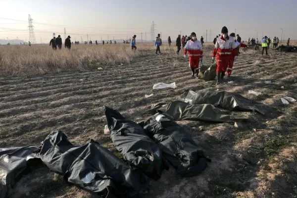 Rescue workers carry the body of a victim of an Ukrainian plane crash in Shahedshahr, southwest of the capital Tehran, Iran, Wednesday, Jan. 8, 2020. A Ukrainian airplane carrying 176 people crashed on Wednesday shortly after takeoff from Tehran's main airport, killing all onboard. (AP Photo/Ebrahim Noroozi)