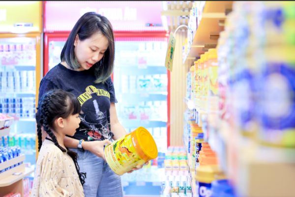 Thúy Ngân cùng con gái tại cửa hàng Vinamilk. Cô cho biết cả hai con của mình đều sử dụng sản phẩm Otimum. Ảnh: Nguyễn Hoàng