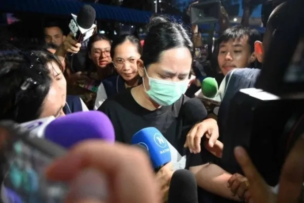 Wilawan Emsawat (giữa) đi giữa vòng vây của phóng viên tại Cục Điều tra Trung ương ở Bangkok, Thái Lan. Ảnh: Bangkok Post