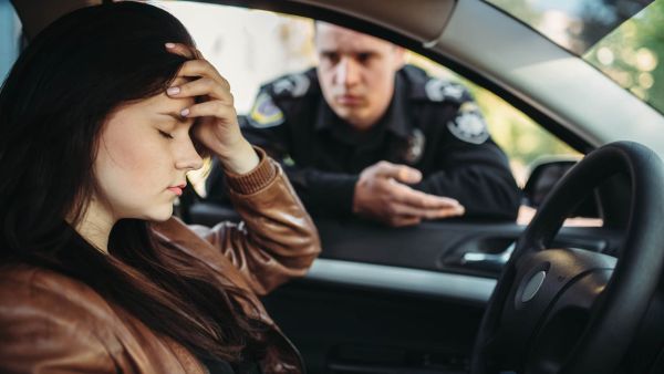 a woman gets pulled over by the police but she realizes she forgot her vehicle registration at home