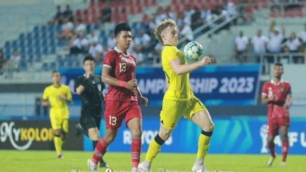 Pemain Malaysia, Fergus Tierney (kanan), saat berduel dengan bek Timnas U-23 Indonesia, Kadek Arel (kiri).