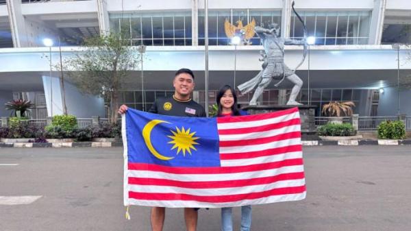 SUPORTER MALAYSIA - Suporter Timnas Malaysia U23 asal Johor, Jonathan Liew (kiri) dengan pasangannya, di Stadion Utama Gelora Bung Karno (SUGBK), Senayan, Jakarta, Senin (21/7/2025). Mereka datang untuk mendukung timnya melawan Indonesia di laga terakhir fase grup Piala AFF U-23 2025.