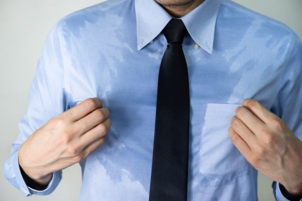 A man in a sweat-stained shirt.