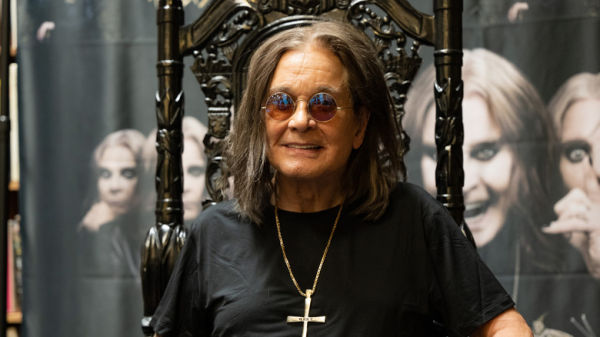Ozzy Osbourne sitting on a gothic-looking high back chair