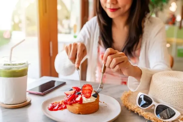 Young Asian woman enjoy eating dessert in cafe on summer vacation trip