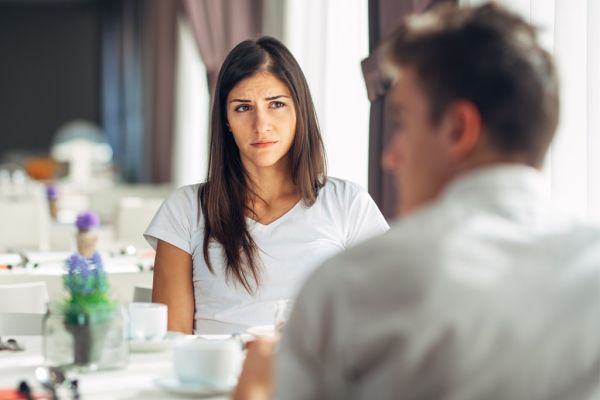 Woman looking unhappy while listening to a man.