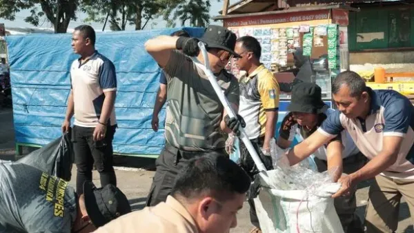 Polisi bersama Pemkab Kuansing bersih-bersih sampah di Tepian Narosa usai Pacu Jalur, Selasa (26/8/2025).
