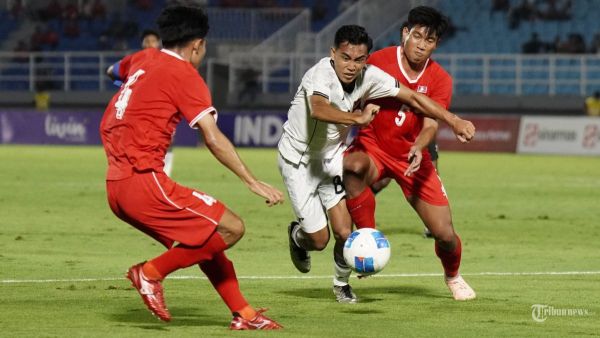 BERDUEL - Pesepak bola Timnas U23 Indonesia, Rayhan Hannan (tengah) diadang dua pesepak bola Laos U23 dalam pertandingan kualifikasi Piala Asia U23 2026 dari Grup J di Stadion Gelora Delta, Sidoarjo pada Rabu (3/9/2025) malam. Timnas U23 Indonesia ditahan imbang Laos dengan skor akhir 0-0. Tribun Solo/Muhammad Nursina