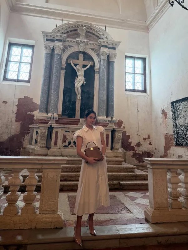 Lee holding a Fendi bag in a Venetian church. Photo from Lees Instagram