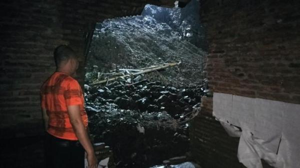TERHANTAM LONGSOR - Joko (ketua RT) saat menunjukan rumah Suparmi yang rusak akibat material longsor