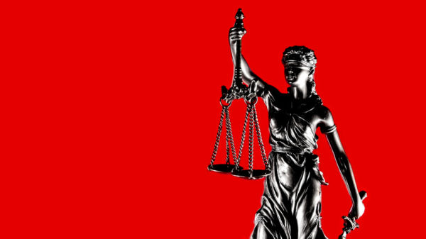 A statue of Justice against a red background.