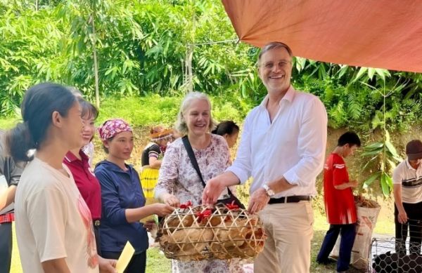 Florence Cavalier and France’s ambassador to Vietnam, Olivier Brochet, donate sows and hens to poor families in Khuoi Chau Village, Vi Xuyen District, Ha Giang, now part of Tuyen Quang Province, in July 2025. Photo courtesy of EPVN