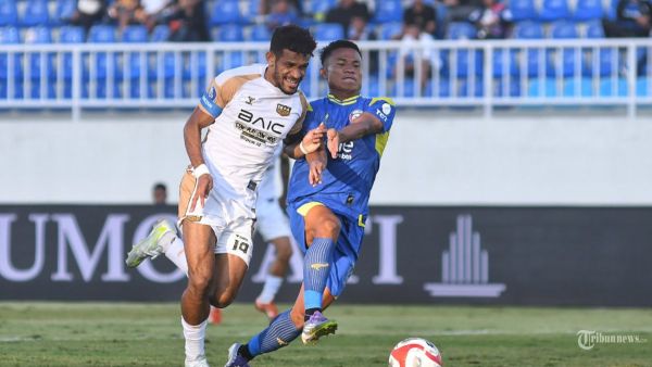 SUPER LEAGUE - Pesepak bola Dewa United Banten FC, Ricki Kambuaya (kiri) berebut bola dengan pesepakbola Arema FC, Bayu Setiawan (kanan) dalam laga lanjutan Super League 2025-2026 di Stadion Kanjuruhan, Kabupaten Malang, Jawa Timur, Sabtu (13/9/2025). Arema FC kalah dari Dewa United Banten FC dengan skor akhir 1-2. SURYA/PURWANTO